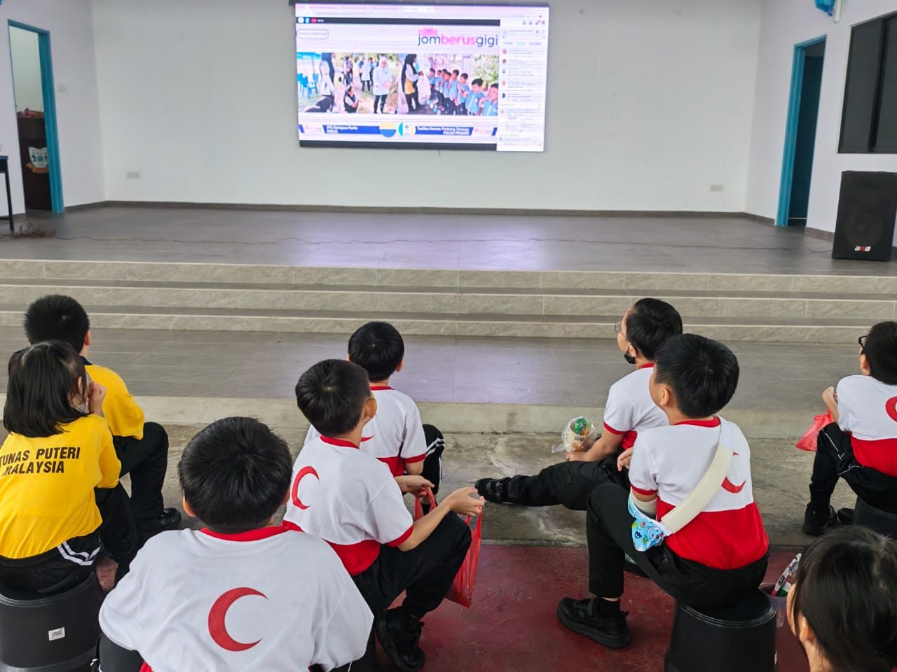 Murid-murid menonton bahan video pendidikan pergigian